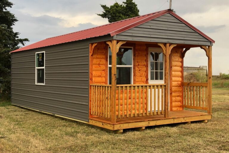 How to finish a cabin shell: View of gray cabin with wooden porch and red roof